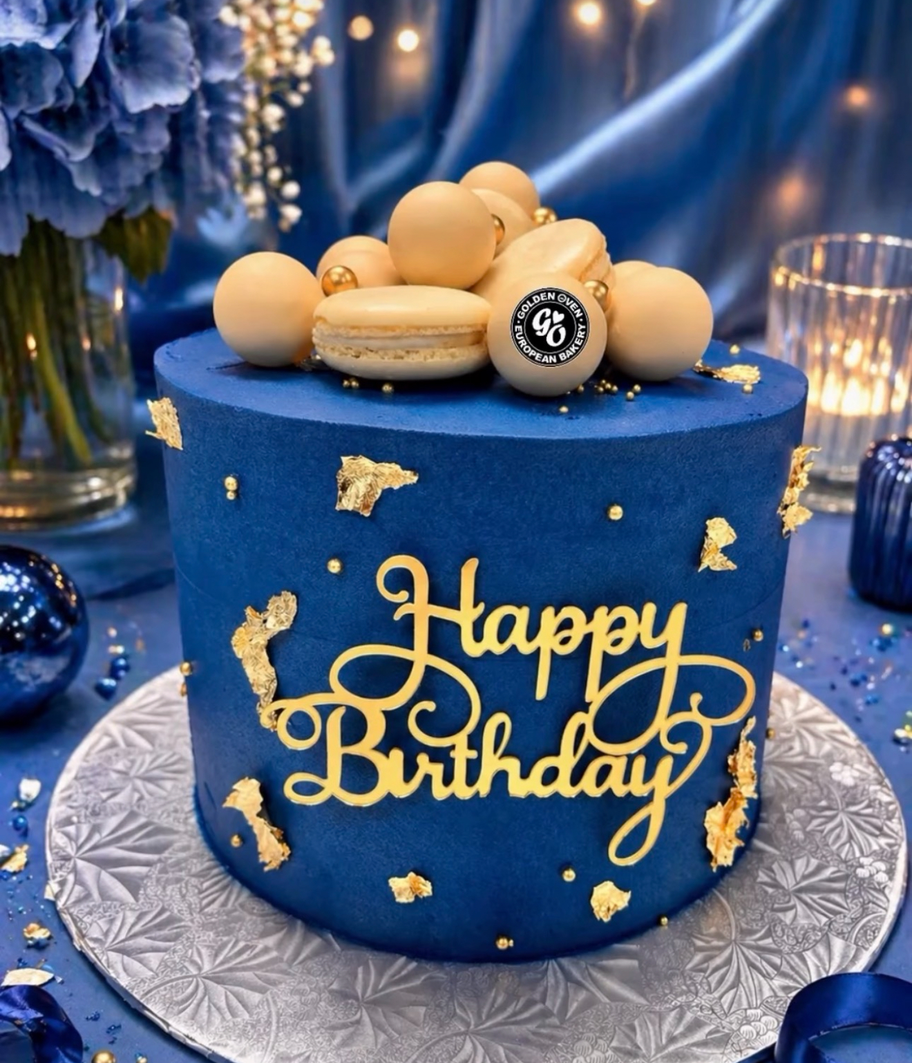 Navy buttercream birthday cake with gold leaf and macarons